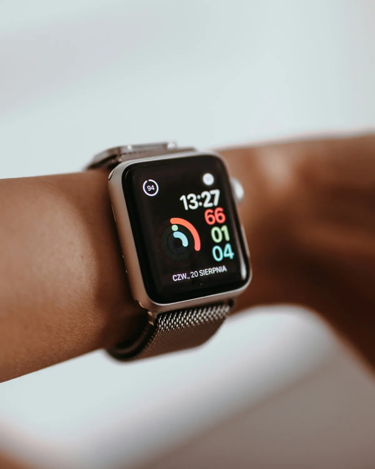 Apple Watch on a wrist showing Activity rings and the time.